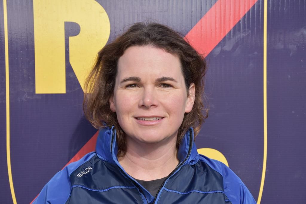 Muireann wearing a Rosemount Mulvey Elite jacket. She had layered shoulder-length dark brown hair, in a centre parting.