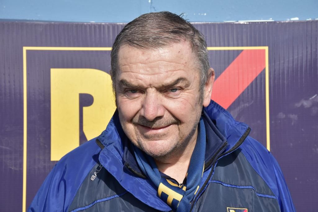 Patsy wear a Rosemount Mulvey Elite jacket and scarf. He has short dark grey hair and is clean shaven.